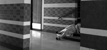 femme allongée dans les escaliers d'un hall d'immeuble du Colombier